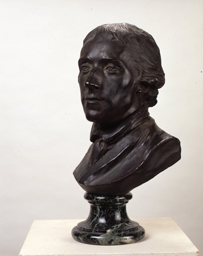 A dark bronze portrait bust of a man with short hair curled above his ears and a serious expression.