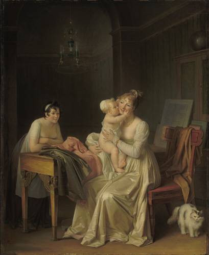 Two women sit on opposite sides of a table draped with cloth. The woman on the nearer side of the table has light skin, light brown or blonde hair, and is wearing a long-sleeved white dress, and she is holding an infant in her arms as it reaches for her face. On the opposite side of the table, the other young woman leans forward with her arms crossed over her chest, elbows on the table. She has light skin, dark curly hair, and wears a light-colored short sleeved dress.