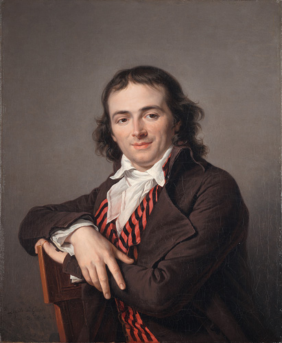 A smiling, light-skinned young man with thin, wavy brown hair that nearly reaches his shoulders. He is seated sideways on a chair with his arms crossed to rest on its back, and he looks away slightly to the right. He is wearing a brown coat, a red-and-black striped waistcoat, and a white shirt with a tall collar.