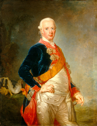 A light-skinned man with white hair curled above his ears, dark eyes, and a slight double chin stands with one hand at his waist. He is wearing a dark blue coat with bright blue lining and trim, large gold-colored hardware on teh front, and an orange sash across his chest. Beneath the coat and sash, he is wearing a shiny off-white shirt and trousers.