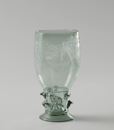 A glass goblet with glass spikes protruding from the short stem. The bowl of the glass is etched with a dragonfly and flower.