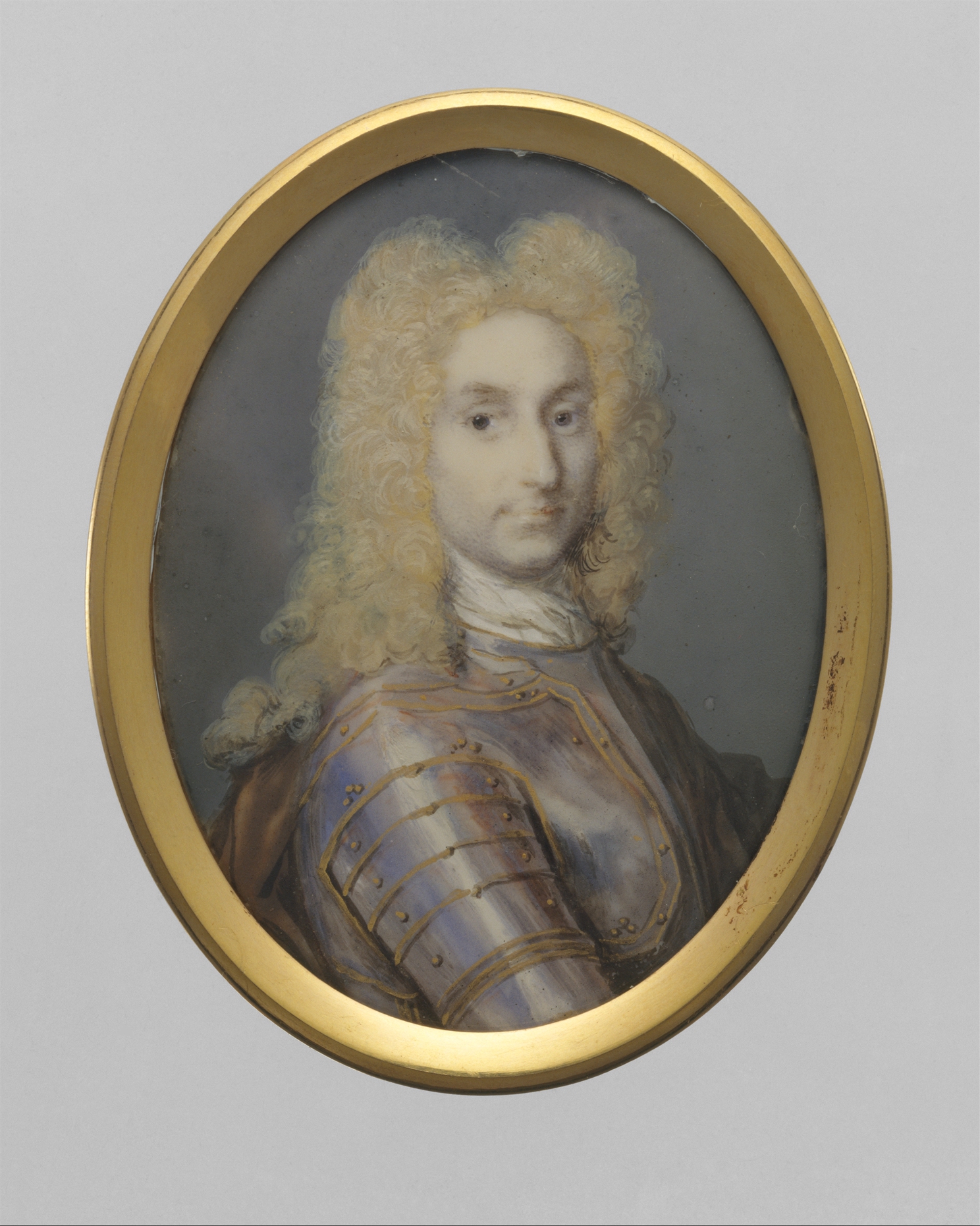 An oval miniature portrait of a man, cropped just below his chest. He is wearing an elaborate eighteenth-century wig and an elaborate costume to match. He looks at the viewer directly.