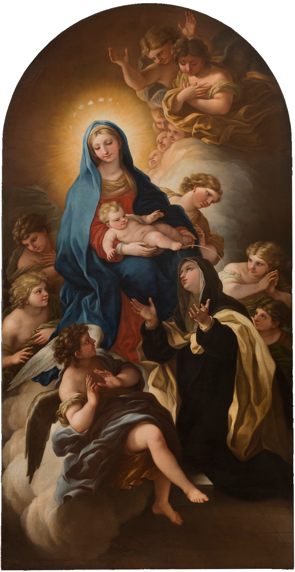 An image of the Virgin Mary holding the infant Jesus, surrounded by angels and other figures. Mary is dressed in blue and pink robes and is crowned with a glowing halo. Another robed, haloed figure is kneeled at her feet, looking up at her and Jesus with arms outstretched. The setting is astral and infused with golden light.