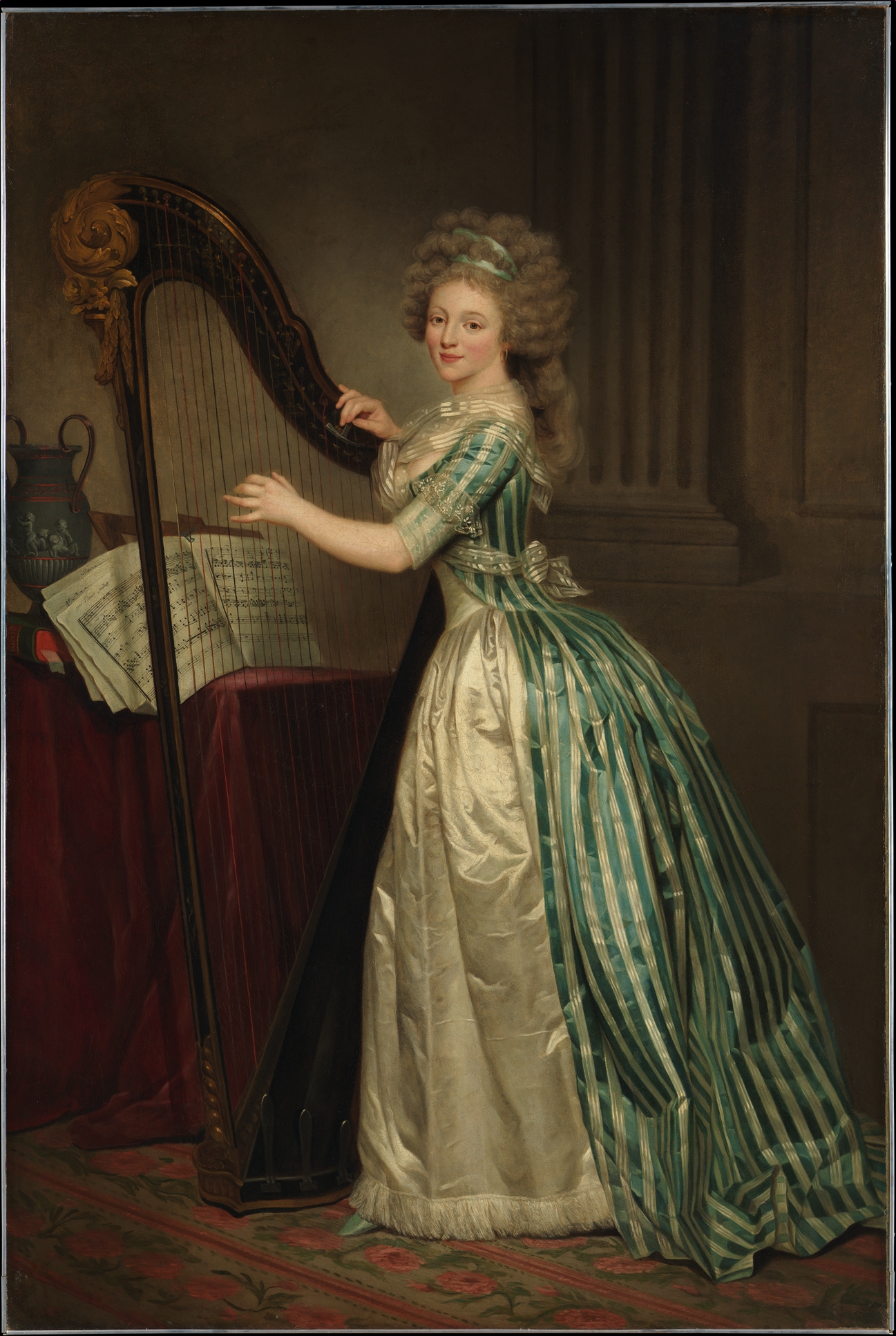 A full-length portrait of a young woman standing at a harp, with the fingers of her left hand resting on the strings and her right hand resting on the frame. She is wearing an elaborate eighteenth-century gown and a gray wig. Behind the harp there is sheet music and a Greek vase arranged on a table draped in red cloth.