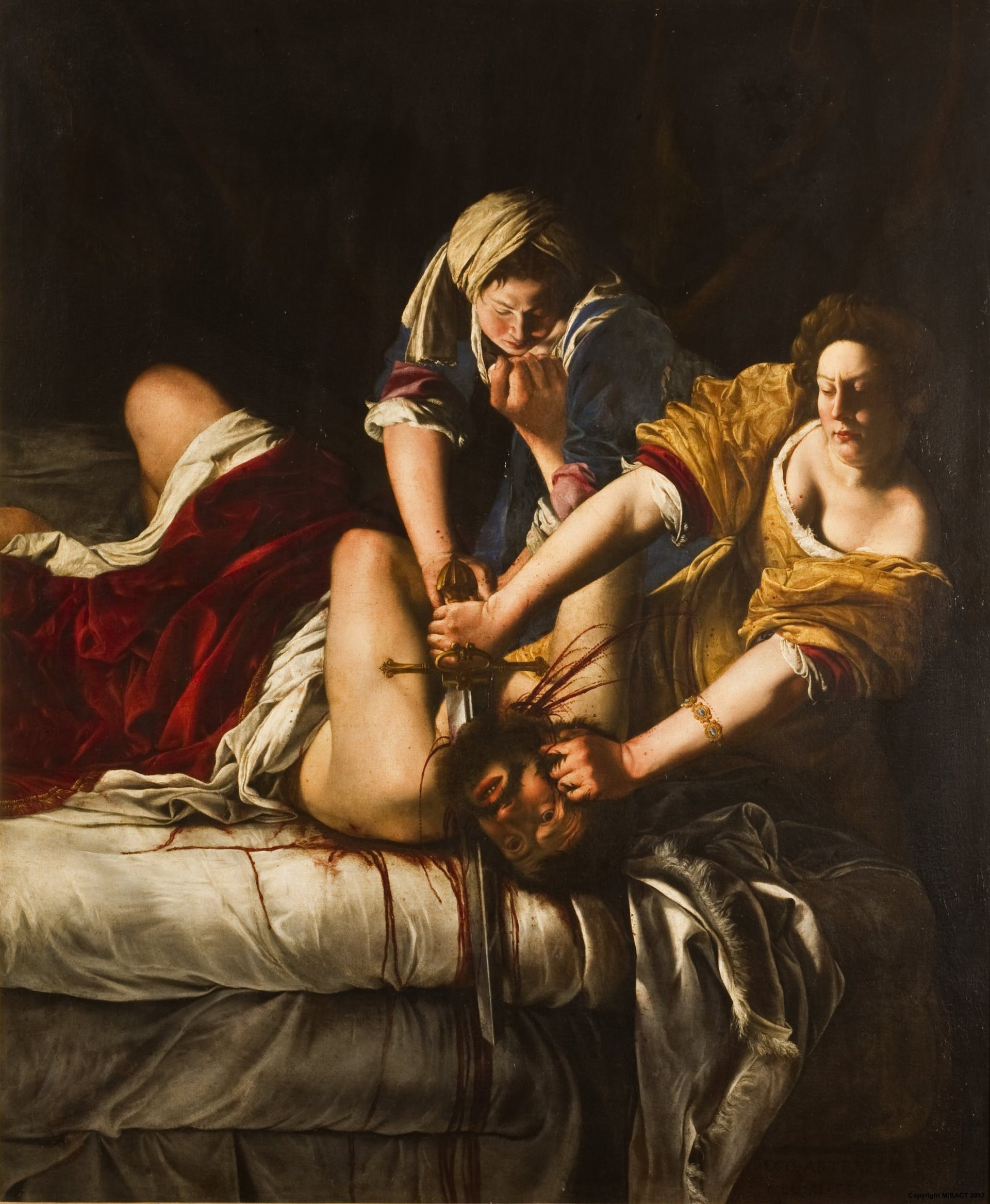 Three figures are centered on the canvas. A man on his back in a bed tries to fight back, kicking his legs and pushing a young woman in a blue dress and white head covering that is holding him down. Another woman in a yellow dress is cutting off his head with a sword. Blood is streaming down the bed and spraying from his neck. The man looks anguished and surprised while the woman in the yellow dress looks determined. Her sleeves are pushed up past her elbows as she completes her task. 