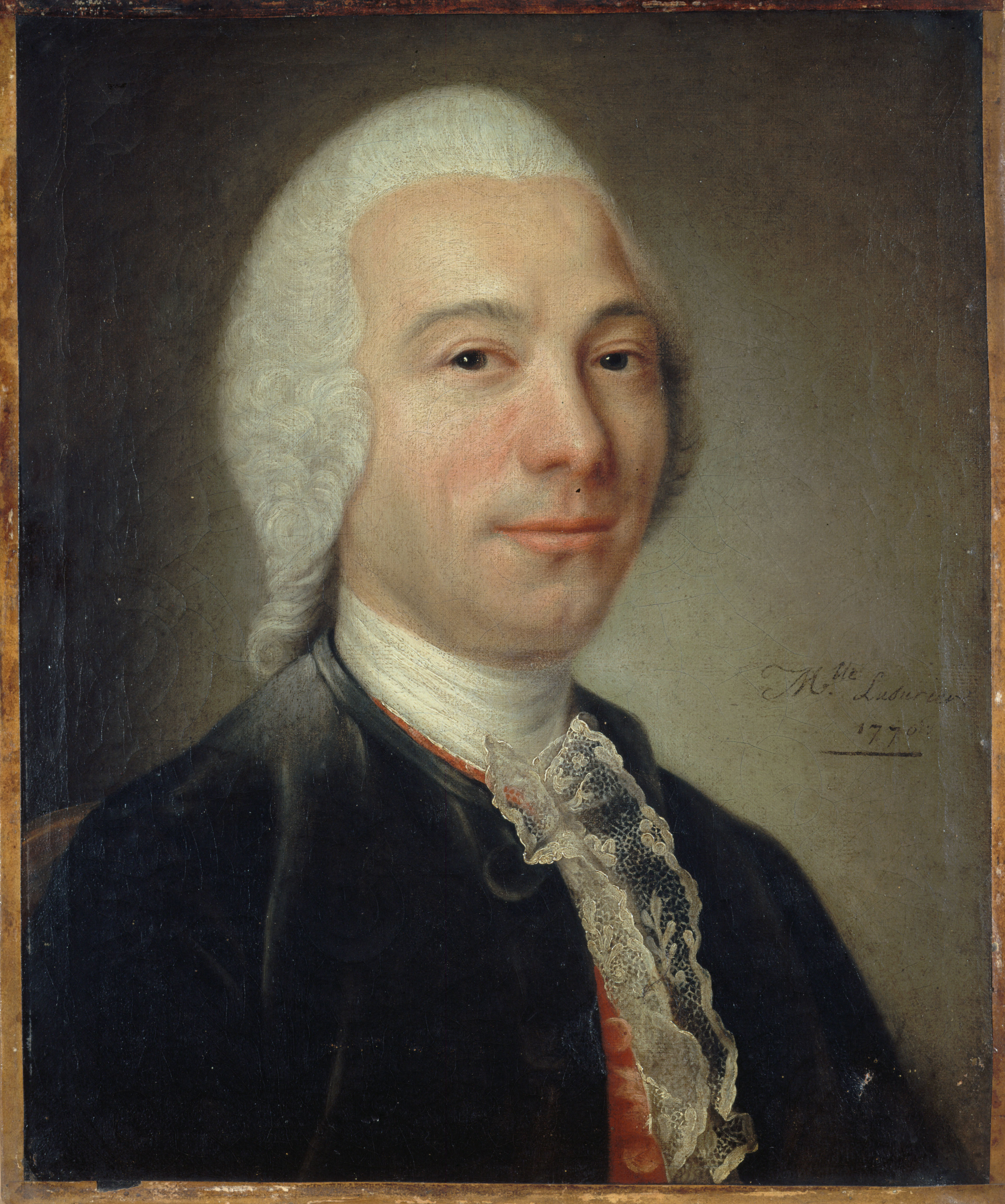 A bust-length portrait of a man wearing eighteenth-century clothing consisting of a blue overcoat, a red vest, and a white shirt with a bit of lace. He wears a white wig and looks out directly at the viewer with a slight smile. The background is neutral, with no other attributes or adornments. 