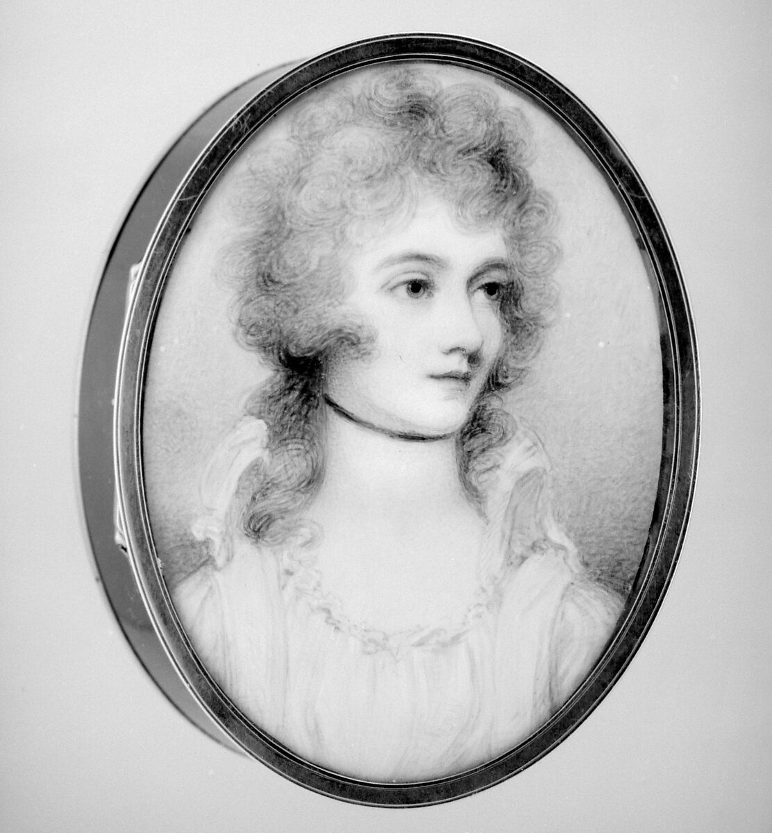 A bust-length portrait miniature of a woman looking off to her left. Her hair is curly, loosely piled on her hear, and she wears a simple choker necklace. She has a soft, neutral expression with large eyes. 