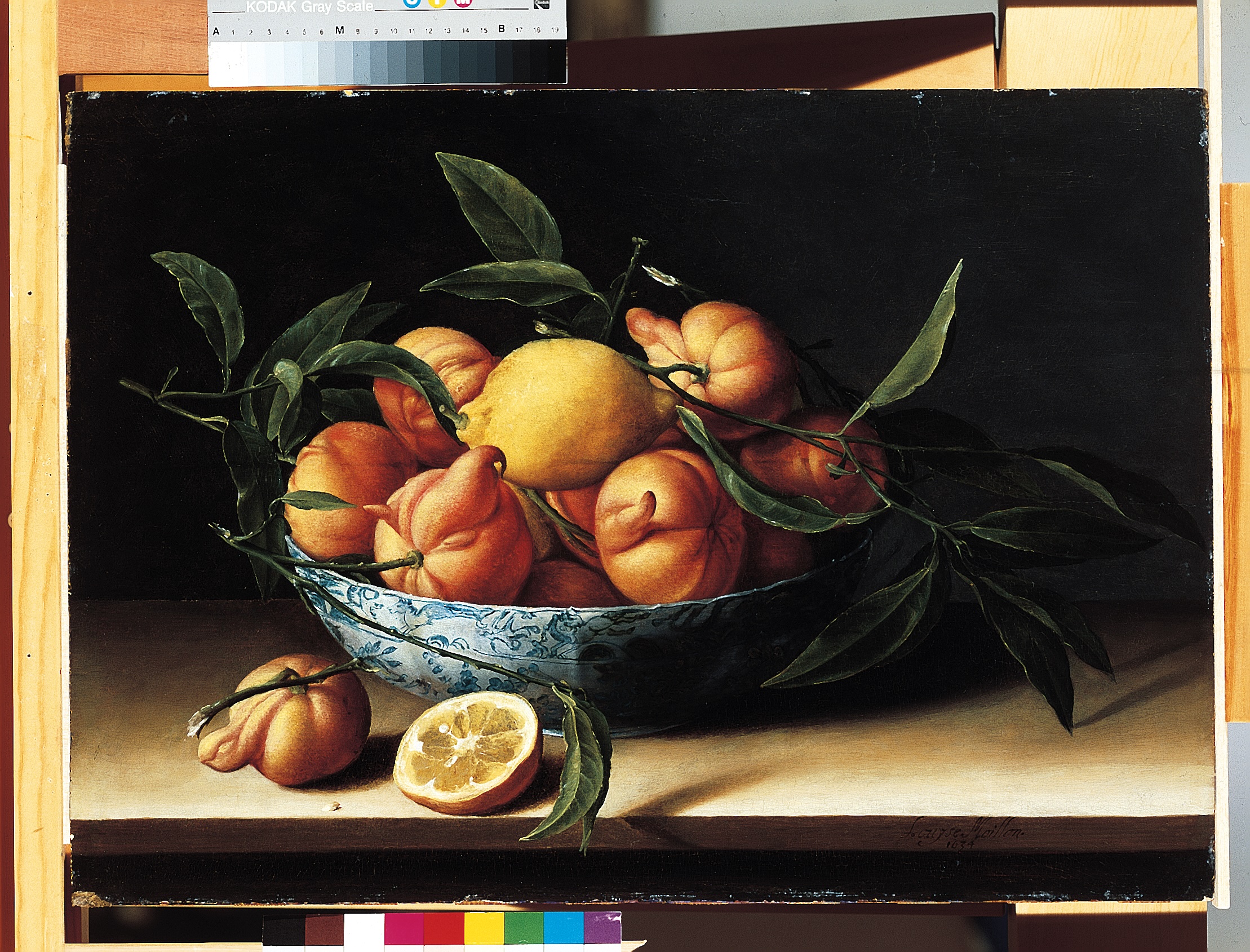 A still-life painting of a bowl of oranges on a table. The bowl is blue and white porcelain, with an intricate design, but the table is quite simple and the background is black. The oranges are arranged with stems and leaves and a single lemon in the center. One half of a cut orange rests on the table. The oranges are misshapen by our modern standards, and do not appear perfectly round.