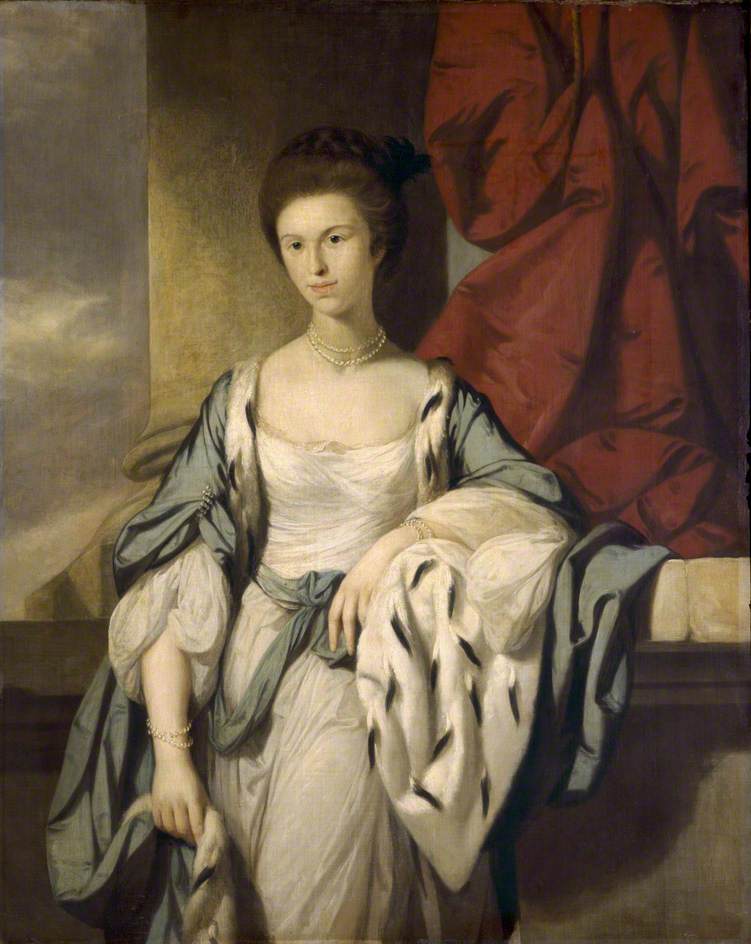 A three-quarters length portrait of a young woman, elaborately dressed in a white gown with a blue cape that is lined in ermine fur. Her brown hair is pulled back and crowned with a braid, and she wears two strands of pearls at her neck and two at her wrist. She looks out with a slight smile. The setting includes a column and red curtain swag behind her, and she leans back, resting her left elbow on the stone ledge.
