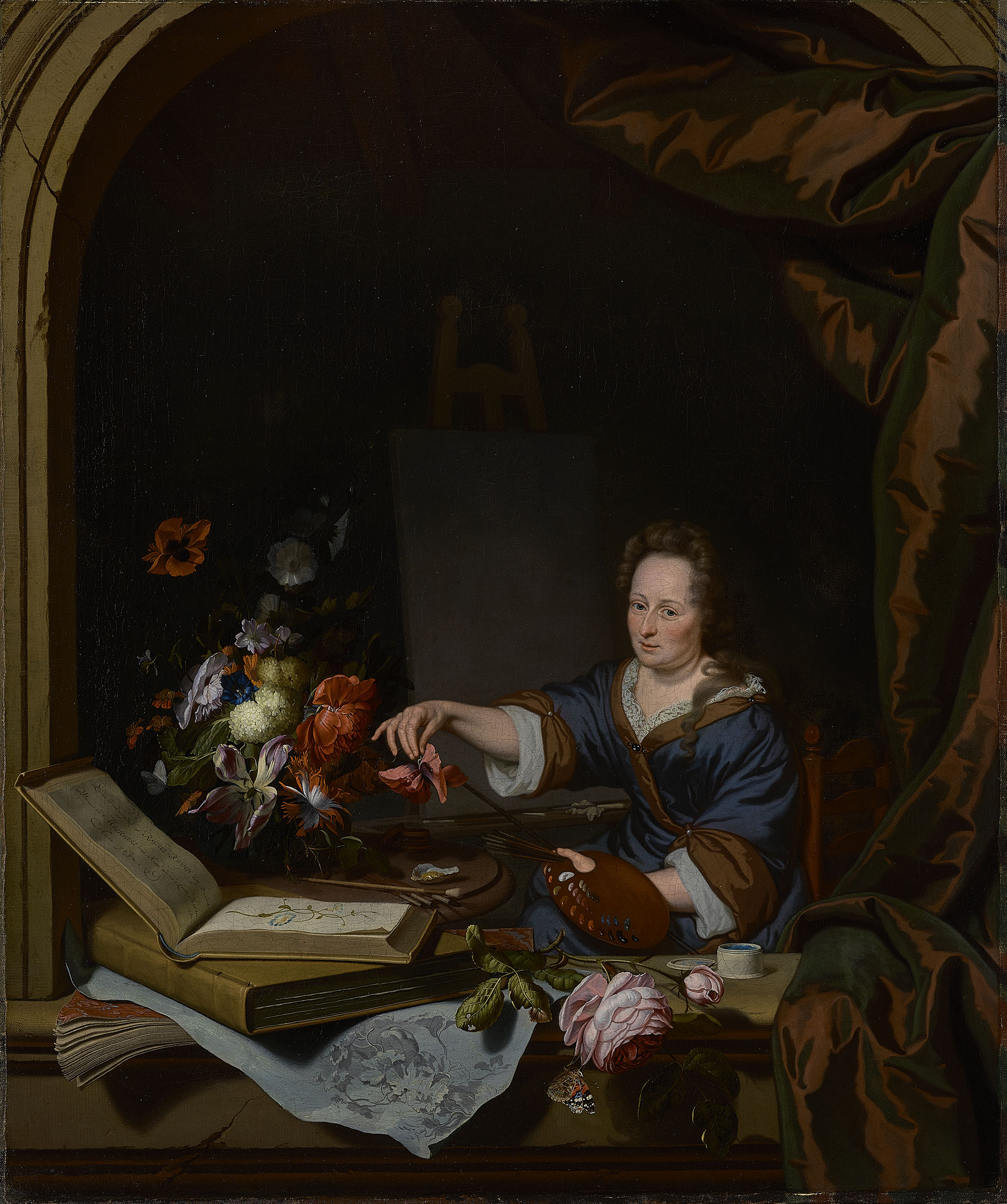 A portrait of the artist sitting at an easel, with flowers, books, and papers in front of her. She holds a palette and brushes in one hand and a flower in the other. She looks out directly at the viewer with a confident, neutral expression. She wears a blue dress trimmed with brown fabric and white lace. The brown color is echoed in a large, satin curtain swag on the right side of the composition. The image is set in a painted, architectural frame, as though we are observing her through an open window.