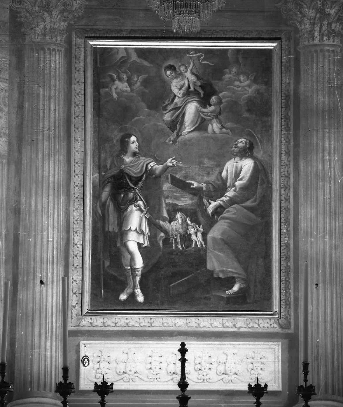 An image of the Virgin Mary and Infant Jesus, with the Infant Saint John the Baptist at her feet, enthroned in the clouds. Below them, Jesus and Saint John the Baptist appear as adults, with Jesus looking up at the clouds above. The painting is set in a frame between two columns, as part of a larger architectural decoration for a church. 