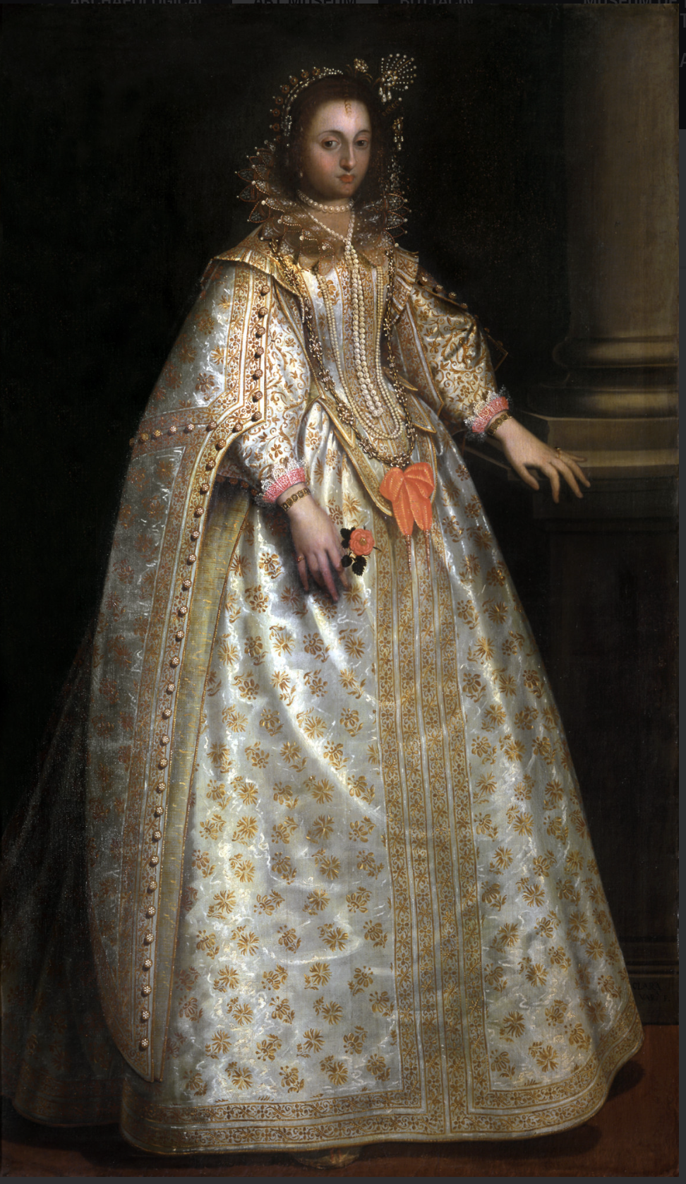 A full-length portrait of a young woman in an extraordinarily elaborate light gray gown with gold embellishments and jewels, as well as pink lace trim and an orange bow. She has a very high, oversized collar and a matching headpiece. She rests one hand on a column and looks directly at the view with a neutral, almost bored expression.