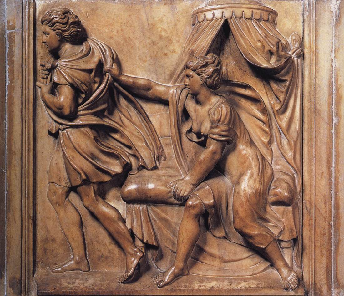 A carved, marble relief of a woman sitting on a bed in a gown with both breasts exposed. She is reaching out to grab the robes of a man who is walking away with his back turned to her. The marble is a warm, light brown color.
